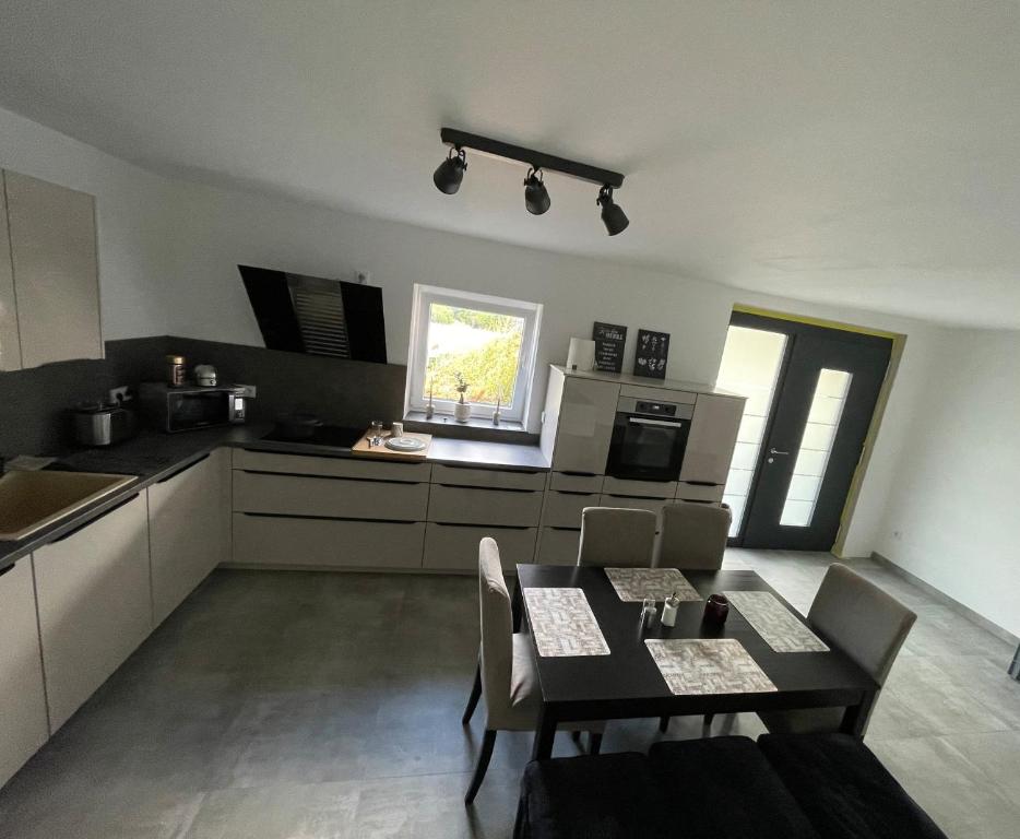 a kitchen with a table and chairs in a room at Ferienwohnung an der Papiermühle 