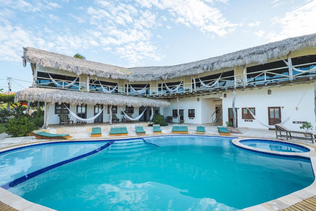 um resort com uma grande piscina em frente a um edifício em 7 Beaufort - Kitesurf Pousada em Itarema