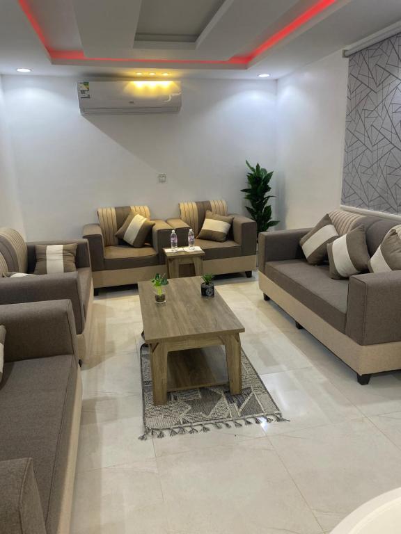 uma sala de estar com sofás e uma mesa de centro em شاليهات بست تايم محايل em Muhayil
