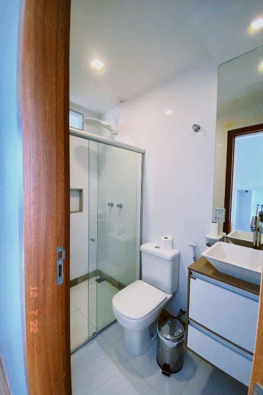 a bathroom with a toilet and a glass shower at Pousada Ritec in Linhares