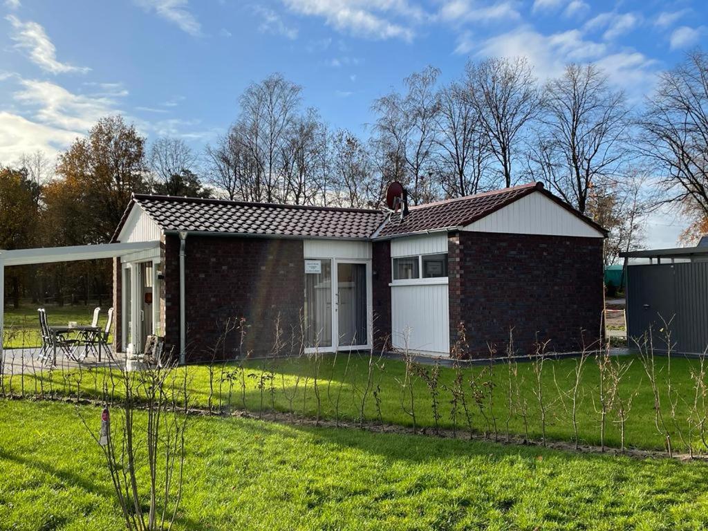 a small brick house with a fence in the yard at Haus Else in Schüttorf