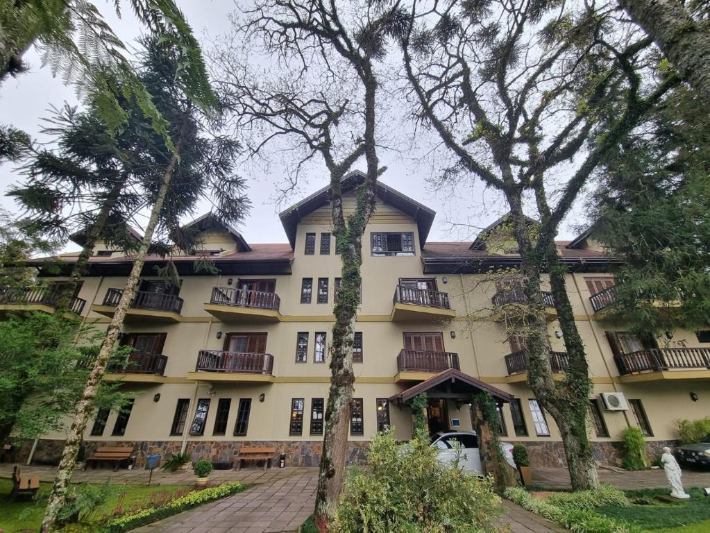 a building with trees in front of it at APARTAMENTO GRAMADO HOTEL in Gramado