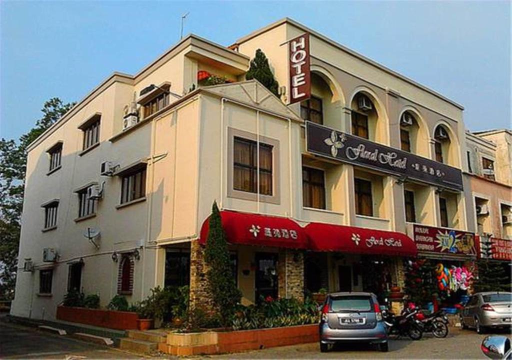 a building with a car parked in front of it at Floral Hotel in Pasir Gudang