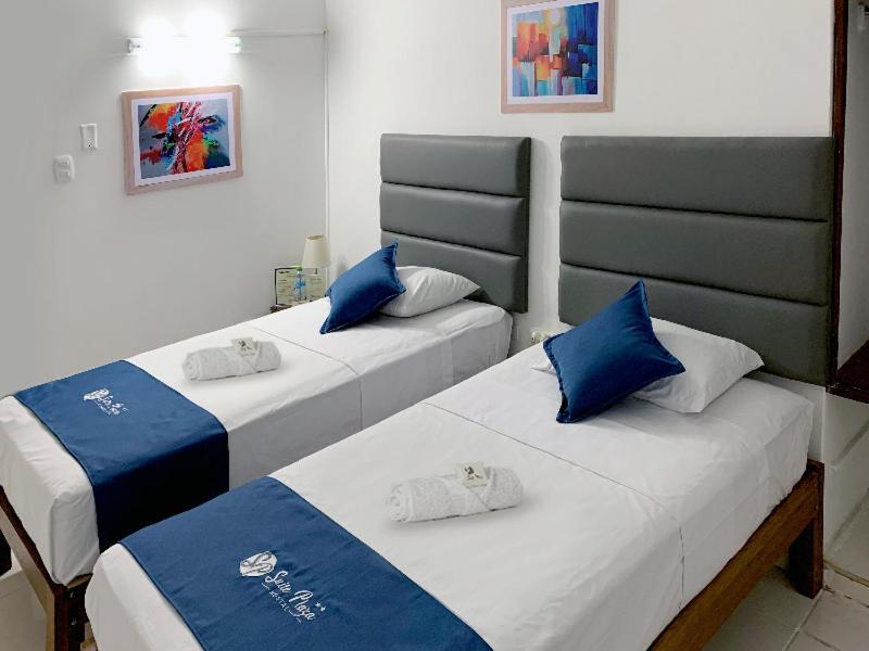 two beds in a room with blue and white at Hostal Resident in Piura