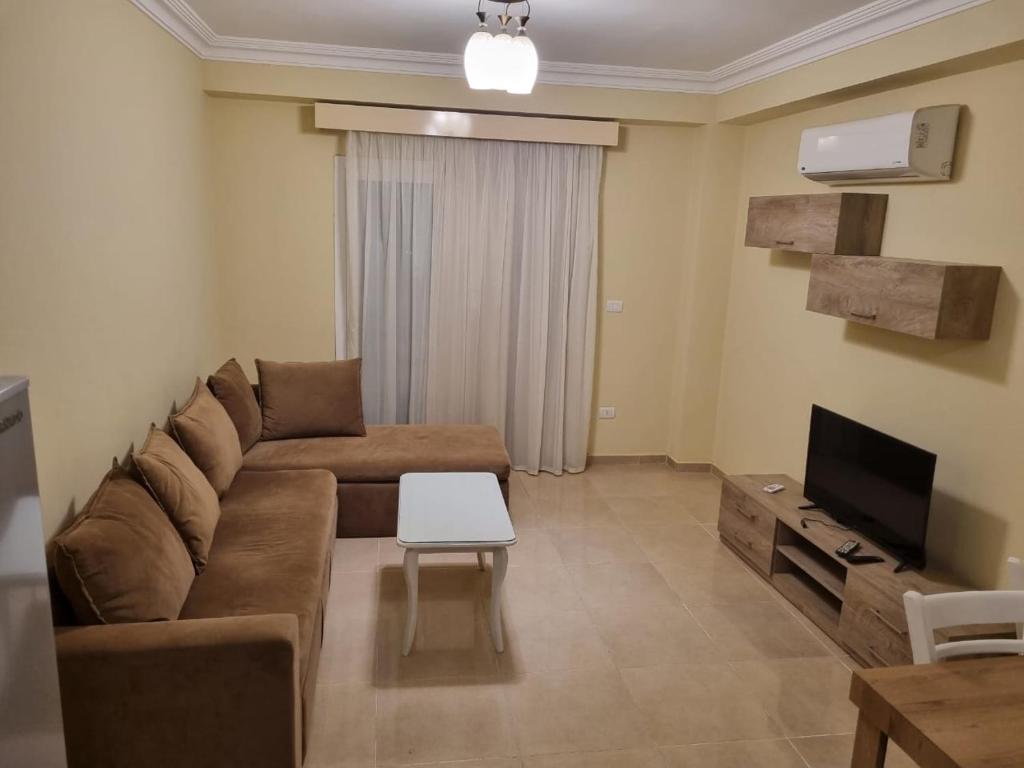 沙姆沙伊赫的住宿－Sharm el sheikh shahd，客厅配有棕色沙发和电视
