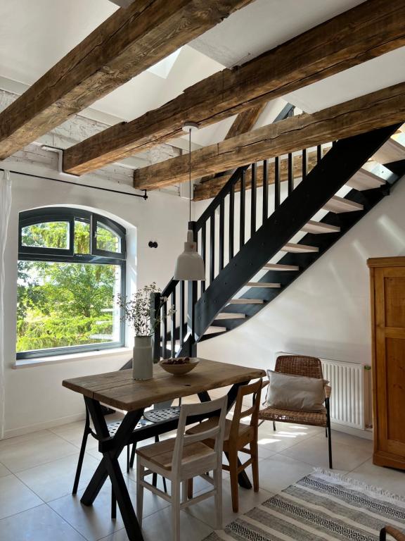 a dining room with a wooden table and stairs at Ublik Stacja in Ublik