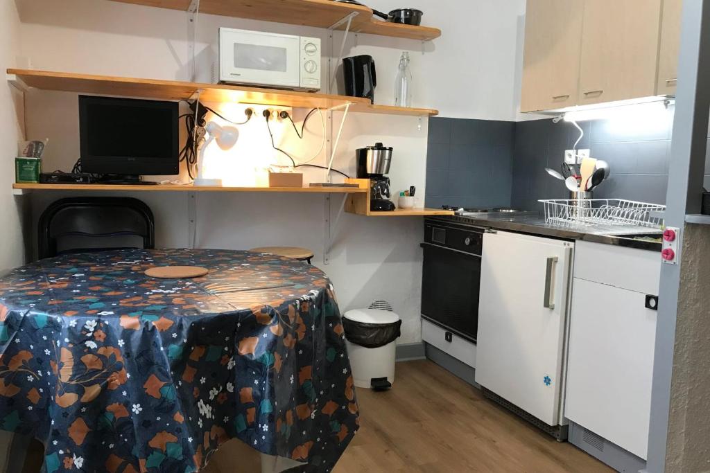 a small kitchen with a table and a microwave at L'Idéal en Charteuse in Saint-Pierre-de-Chartreuse