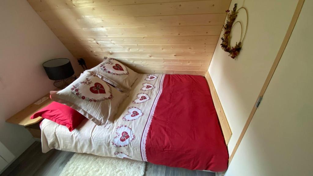 a bed in a small room with a wooden ceiling at Au-Doux-Altic chalet romantique avec JACUZZI ET SAUNA in Métabief