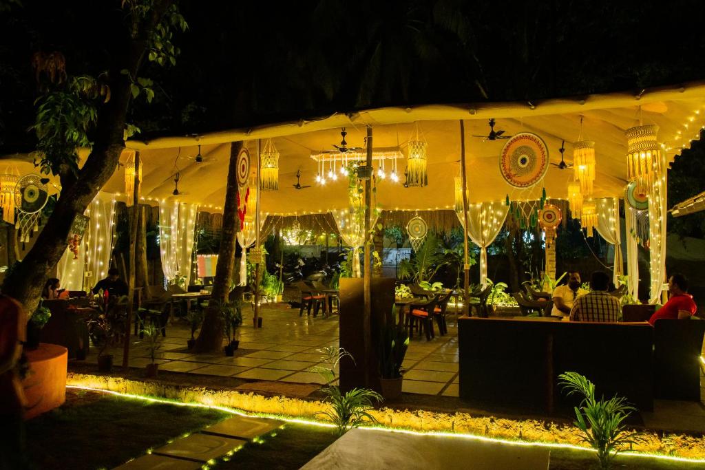 a restaurant with lights and people sitting at tables at BunkNBrew in Palolem