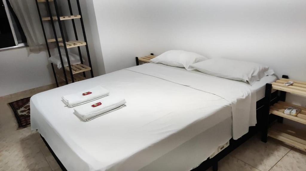 een wit bed met twee witte handdoeken erop bij Apartamento dunas cabo frio in Cabo Frio