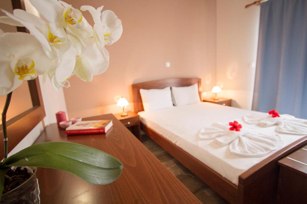 pokój hotelowy z łóżkiem z białą pościelą i kwiatami w obiekcie Falassarna Beach studios&apartments w mieście Falasarna