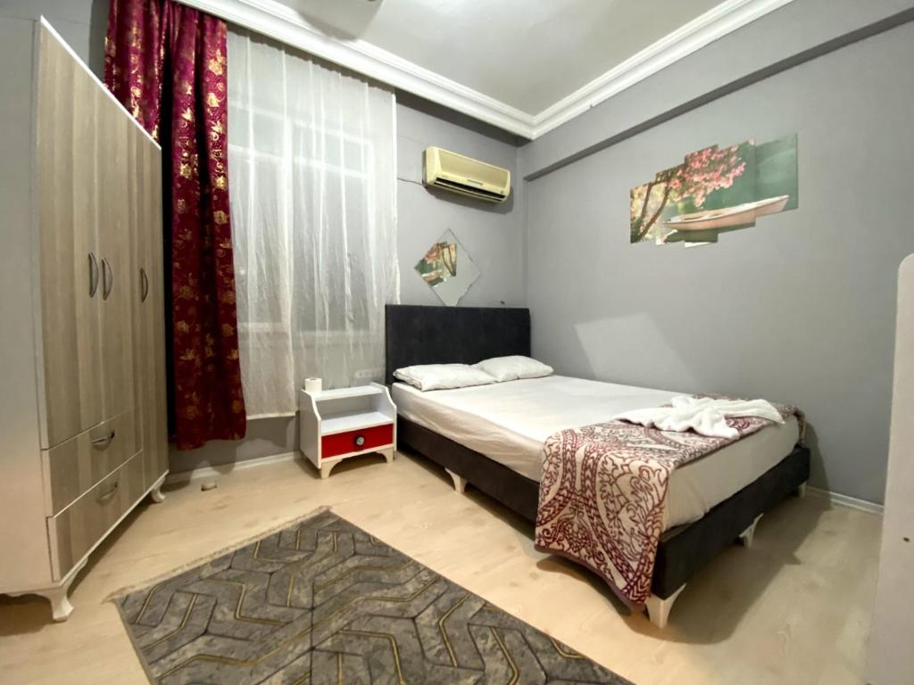 a small bedroom with two beds and a window at Red White House in Antalya