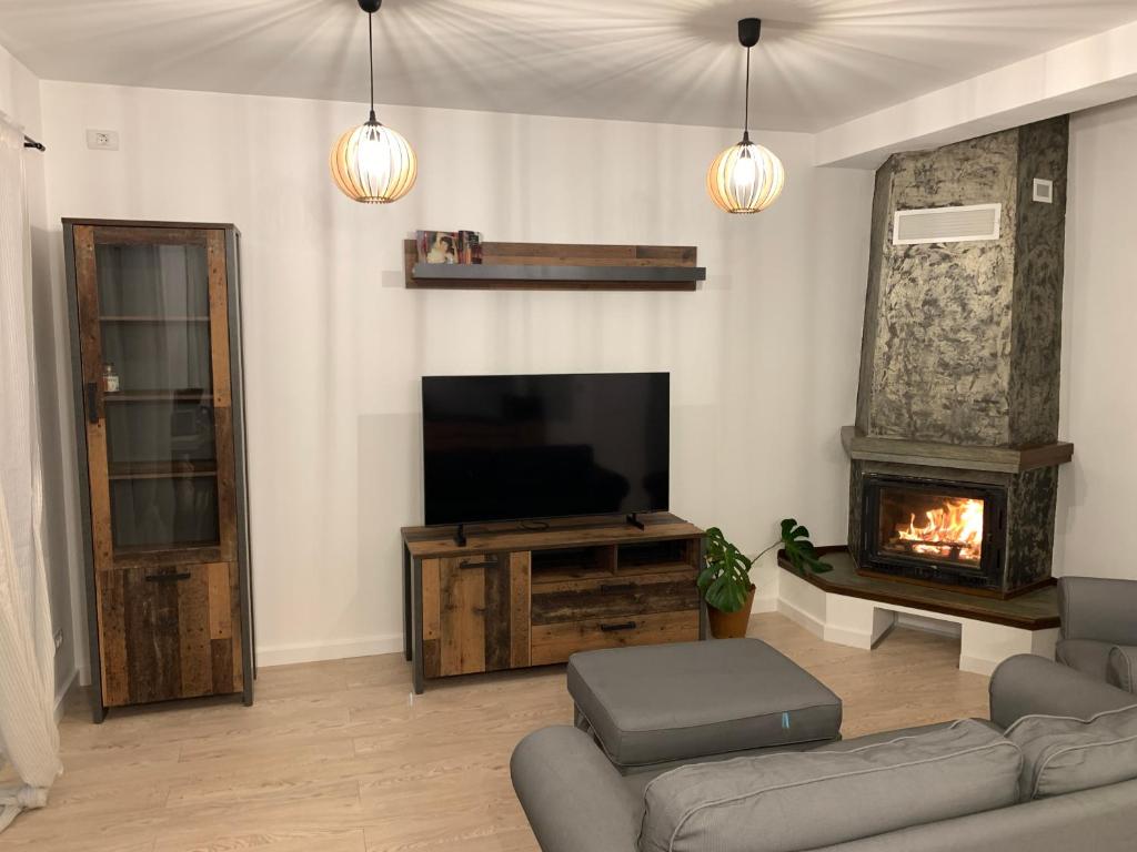 a living room with a television and a fireplace at DUO Residence in Dumbrăviţa