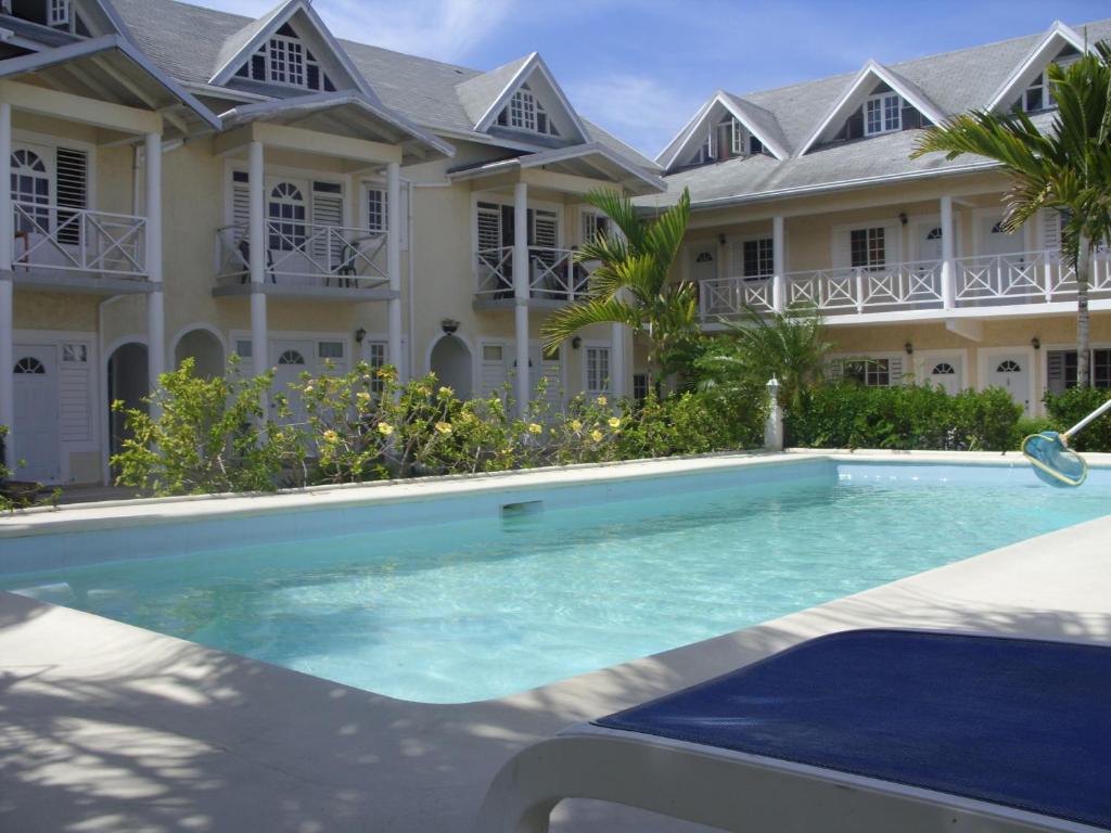 a villa with a swimming pool in front of a building at Dreamy Haven in Runaway Bay