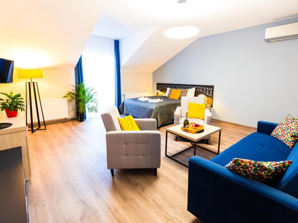 uma sala de estar com um sofá azul e uma cama em Willa Moćkówka em Busko-Zdrój