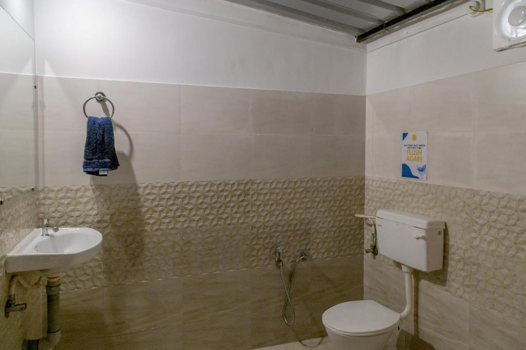 a bathroom with a toilet and a sink at BunkNBrew in Palolem