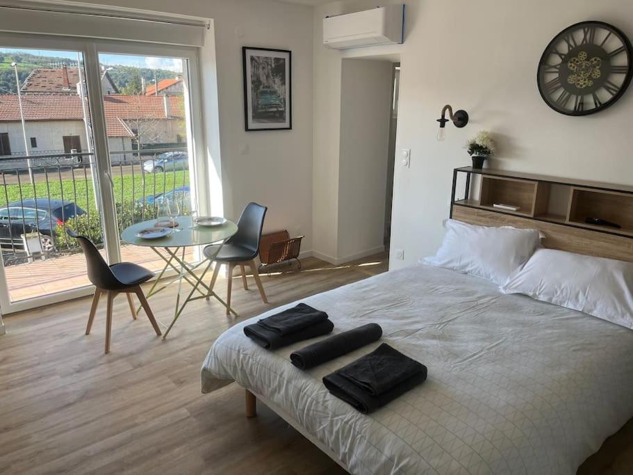 een slaapkamer met een bed met twee zwarte handdoeken erop bij WAGNER’studio BALNÉO’terrasse au calme in Chasse-sur-Rhône