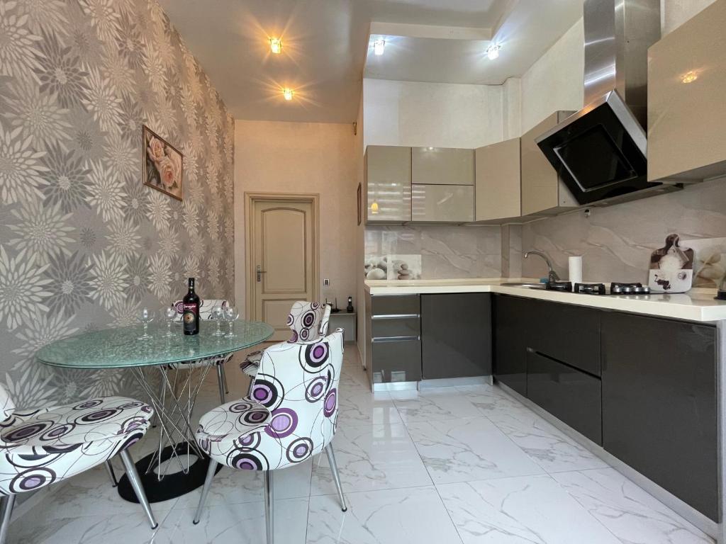 eine Küche mit einem Tisch und Stühlen in der Unterkunft Continental apartment in Baku