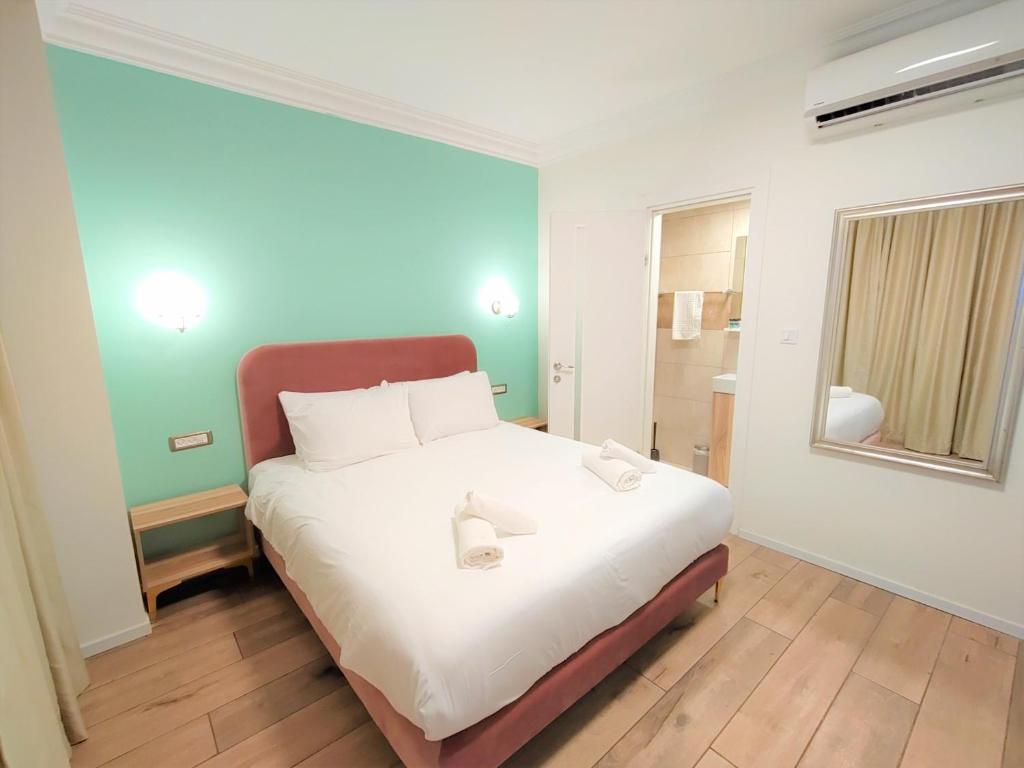 1 dormitorio con 1 cama blanca grande y ventana en La Perle Hotel, en Jerusalén