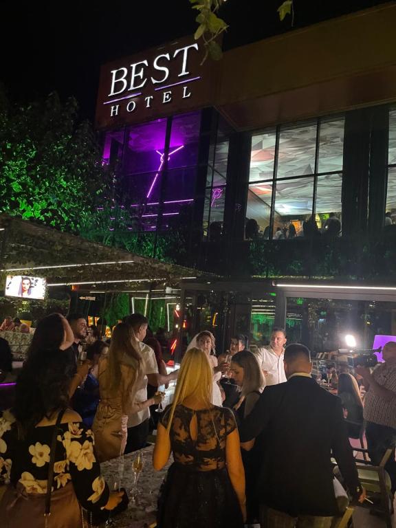 a group of people sitting at a restaurant at night at Hotel Best in Ploieşti