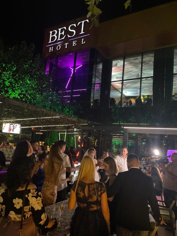 un grupo de personas sentadas en un restaurante por la noche en Hotel Best, en Ploieşti