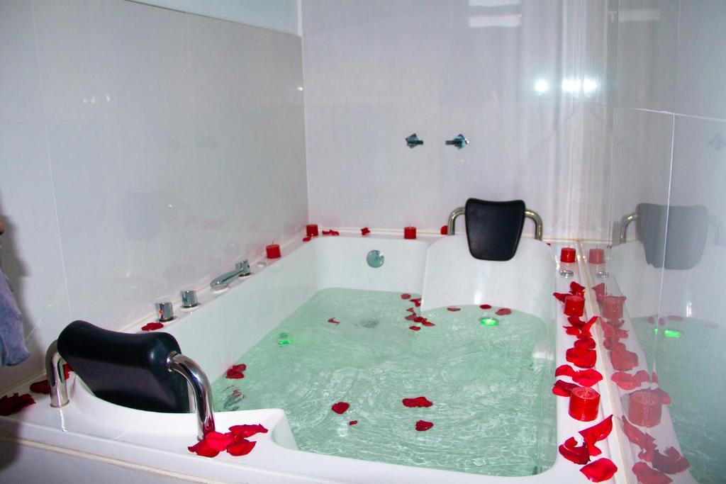 W łazience znajduje się wanna wypełniona czerwonymi różami. w obiekcie HOTEL KILLASUMAQ w mieście Cajamarca