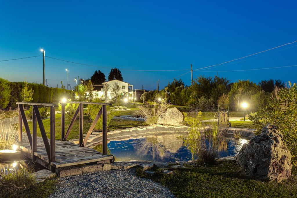 un puente sobre un estanque en un parque por la noche en I Delfini - Natural B&B, en Cesenatico