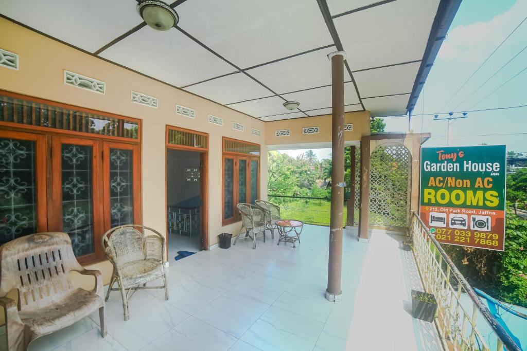 una casa con portico con sedie e un cartello di Tony's Garden House Back Packers inn a Jaffna