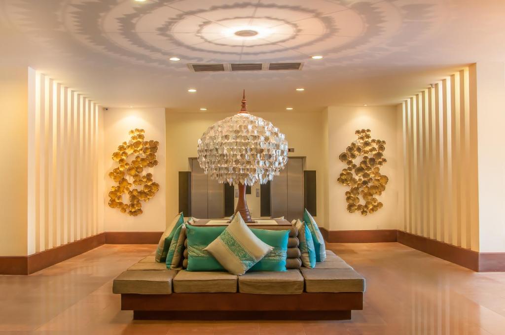 a room with a chandelier and a couch with pillows at THE PRIVILEGE FLOOR by Lotus Blanc in Siem Reap