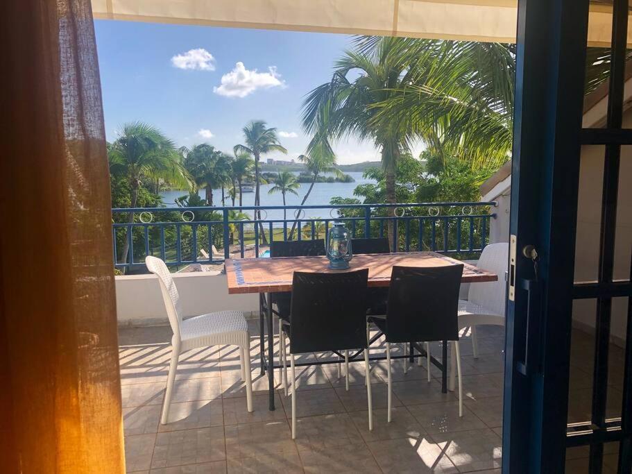 a table and chairs on a balcony with a view of the water at Apt 2 chambres Vue Lagon in Saint Martin