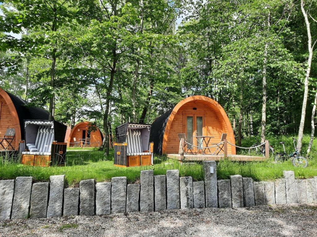 25 Premium Camping Pod في Silberstedt: مجموعة من الخيام في الغابة خلف سياج
