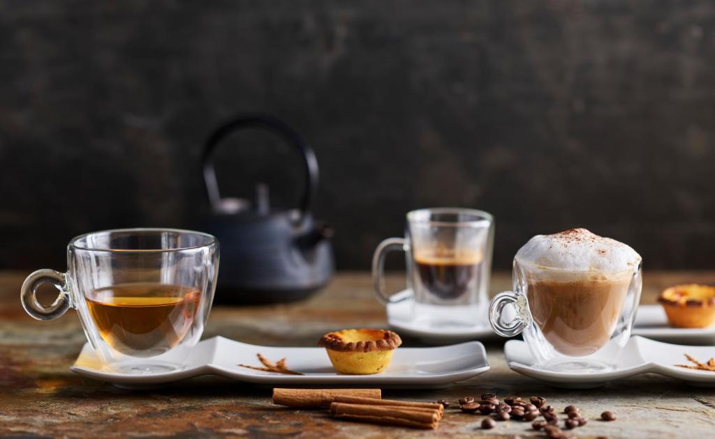 Coffee drinks and small pastries arranged on a breakfast table.