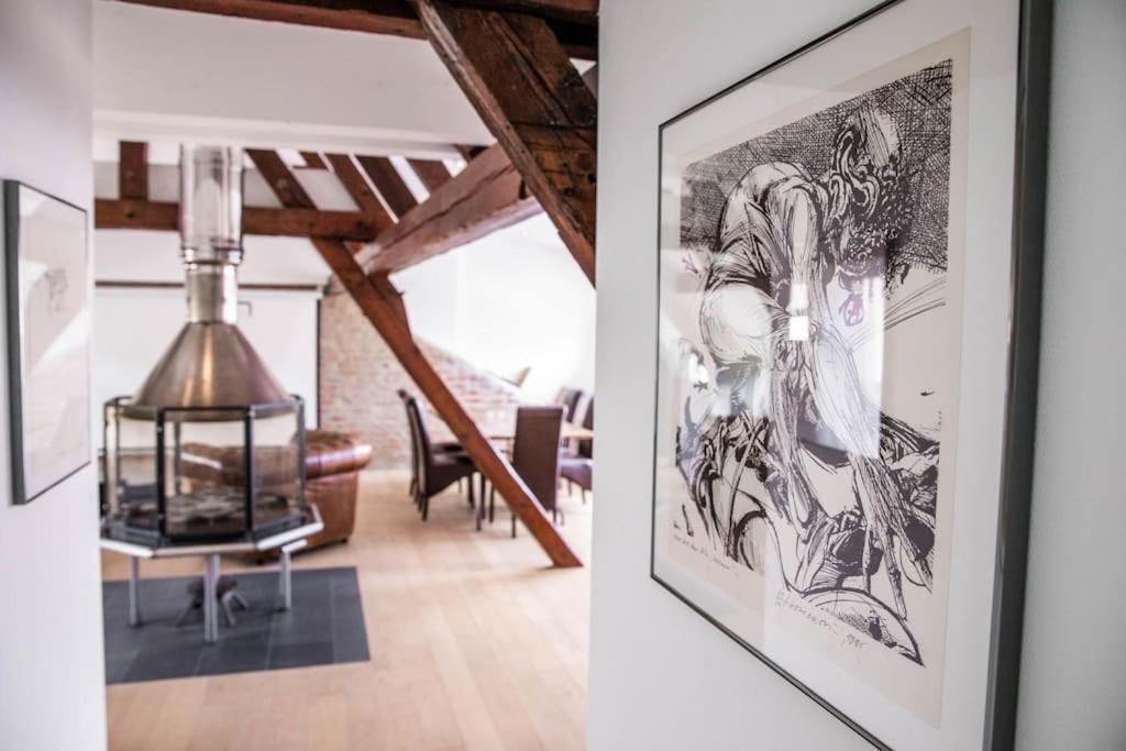 a living room with a drawing of a woman on the wall at L'Appartement des Artistes avec Terrasse in Kaysersberg