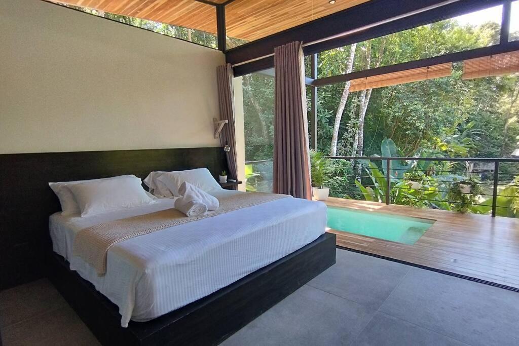 a bedroom with a bed and a balcony with a tub at Casa Sol y Luna, Santa Teresa in Santa Teresa Beach
