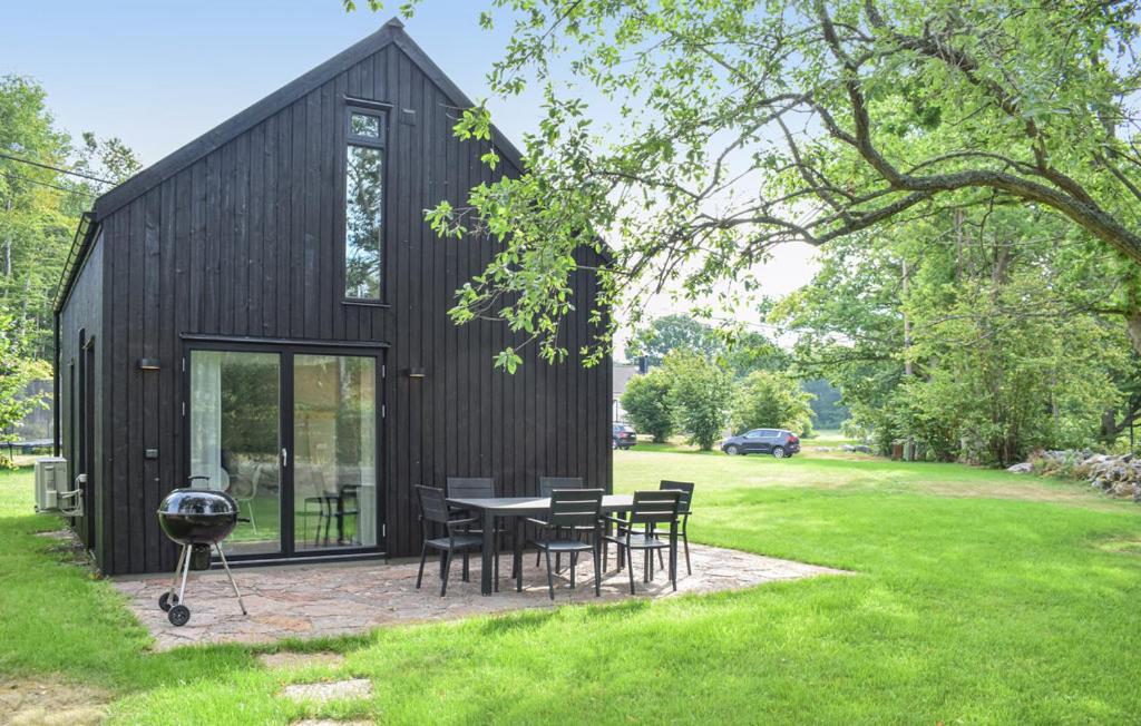 a black house with a patio and a grill at Guest house on Fäjö in Lyckeby