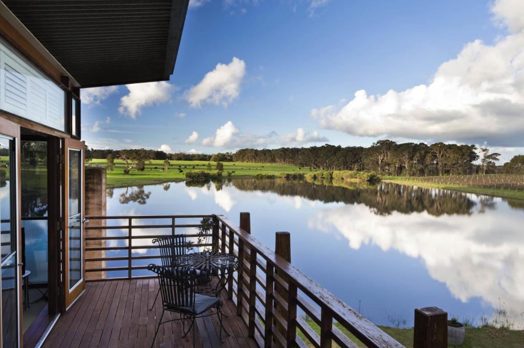 a deck with a view of a lake with a table and chairs at Bettenays Margaret River in Metricup