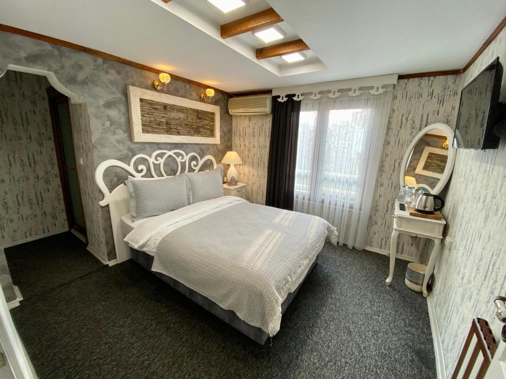 a bedroom with a white bed and a mirror at Peri Boutique Hotel in Sapanca