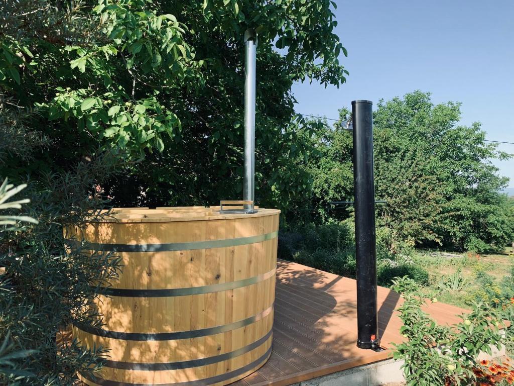 un barril de madera con un poste en un jardín en Fügéskert en Balatongyörök