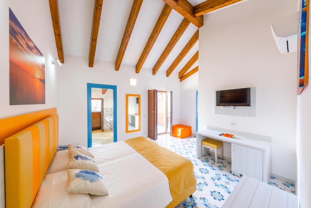 1 dormitorio con 1 cama grande y TV en Costa Blu en Agerola