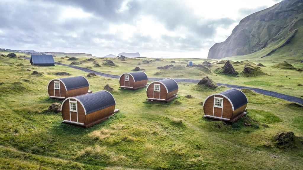 um grupo de minicasas num campo relvado em Glamping & Camping em Vestmannaeyjar