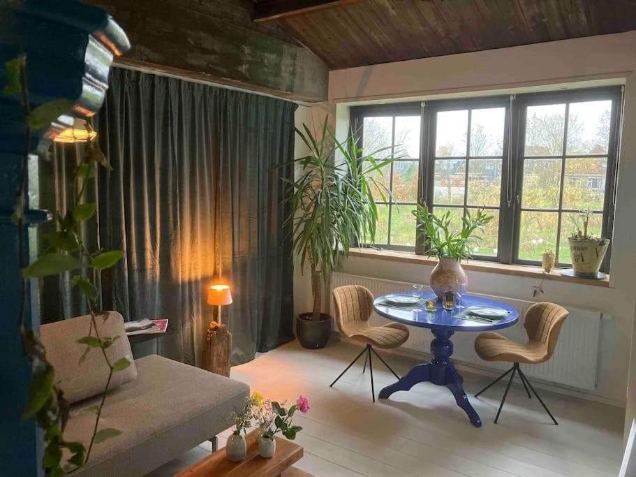 een woonkamer met een tafel en stoelen en een bank bij Appartement de Tuinkamer in Kampen