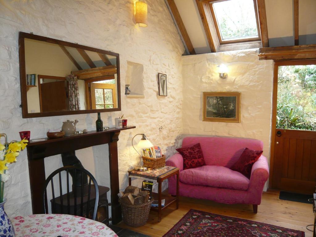 a living room with a pink couch and a mirror at Loveston barn in Kilgetty
