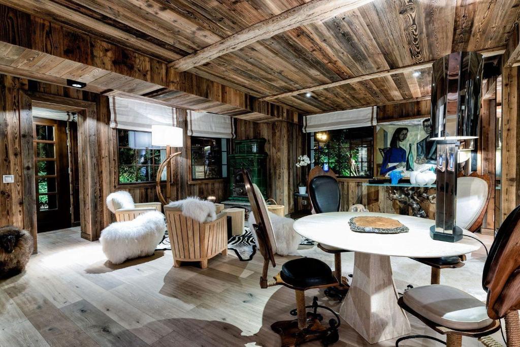 um quarto com paredes de madeira e uma mesa e cadeiras em Nice view and only the rush of the river below to lull you to sleep em Visp