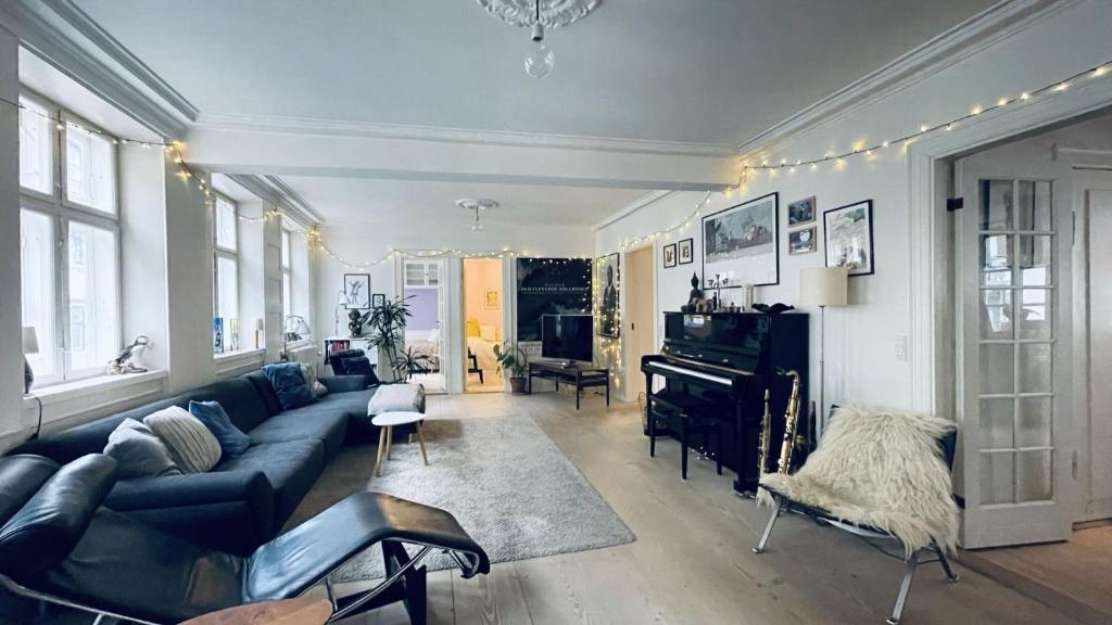 sala de estar con sofá azul y piano en ApartmentInCopenhagen Apartment 17 en Copenhague