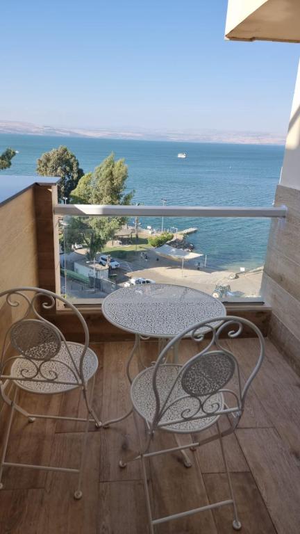 a table and chairs on a balcony with a view of the ocean at Kings Towers in Tiberias
