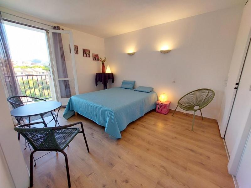 une chambre avec un lit, une table et des chaises dans l'établissement CAPET LES DAHLIAS - Axelle Loc'Appart, à Sainte-Maxime