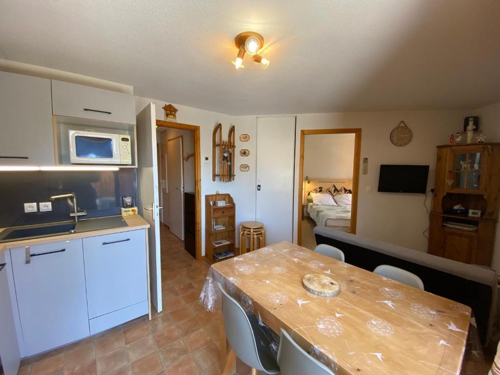 kuchnia ze stołem oraz pokój z łóżkiem w obiekcie Appartement cosy avec Multi Pass offert, à 10 minutes du centre de Châtel et proche des remontées - FR-1-693-7 w mieście Châtel