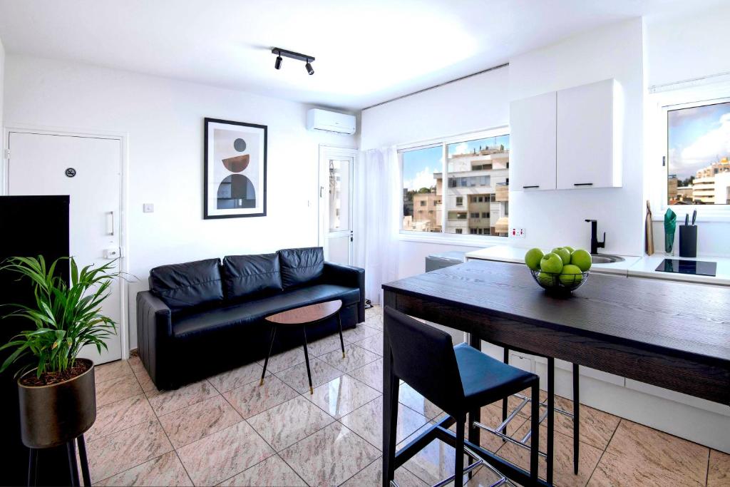 a kitchen and living room with a table and a couch at Urban Condo 43 - 1 Bdr in Nicosia