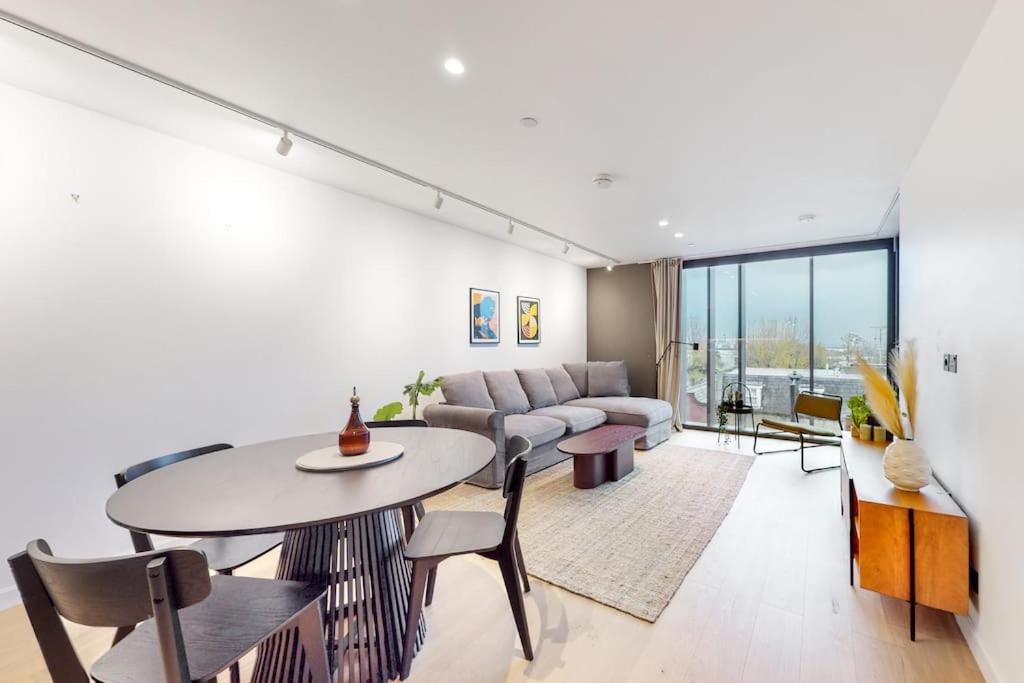 a living room with a table and a couch at Modern 1 bed flat with balcony in Kensal Green in London