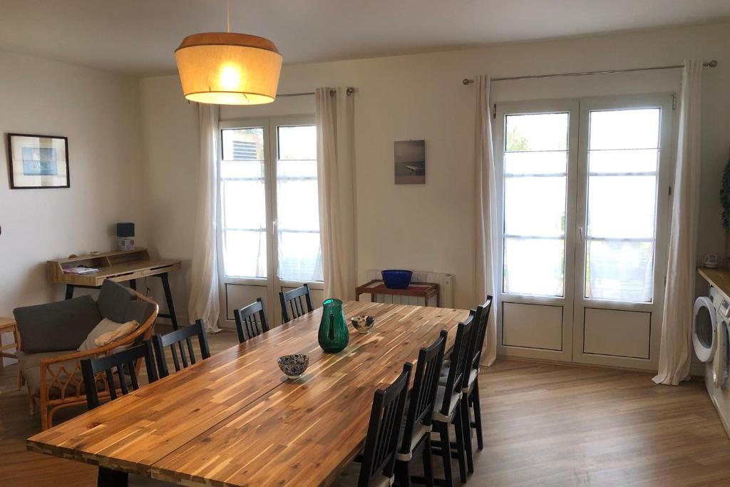 - une salle à manger avec une table et des chaises en bois dans l'établissement Nice 120m with garden near the sea, à Sainte-Marie de Ré